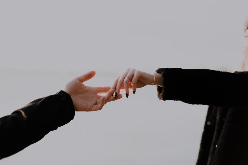 two hands reaching for each other
