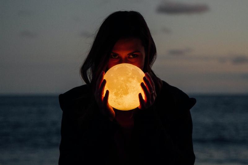 woman holding moon between her hands