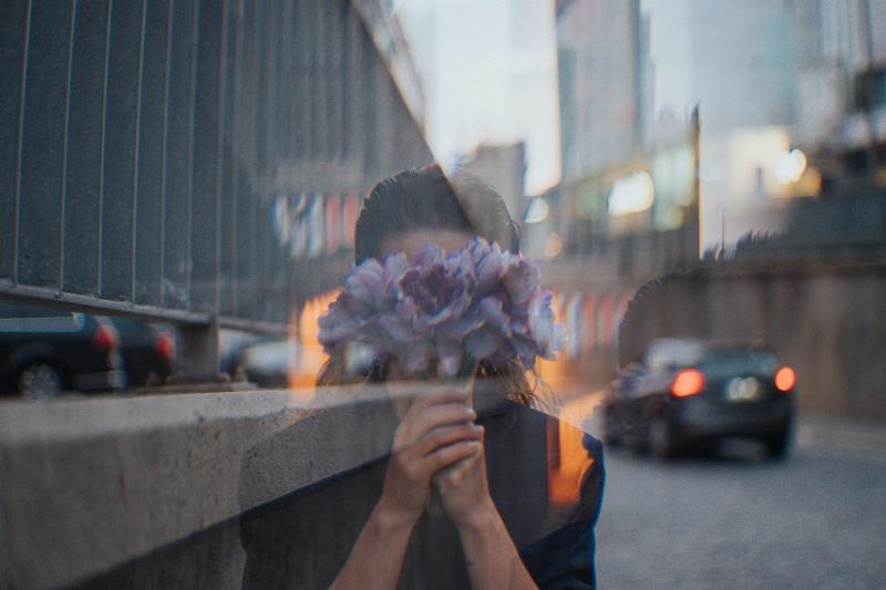 woman hides her faces with bouquet as a ghost