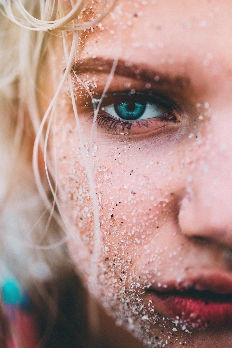 woman with green eye ball and sand all over her face