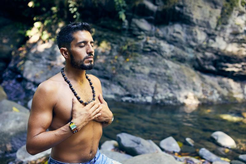 man meditating by river