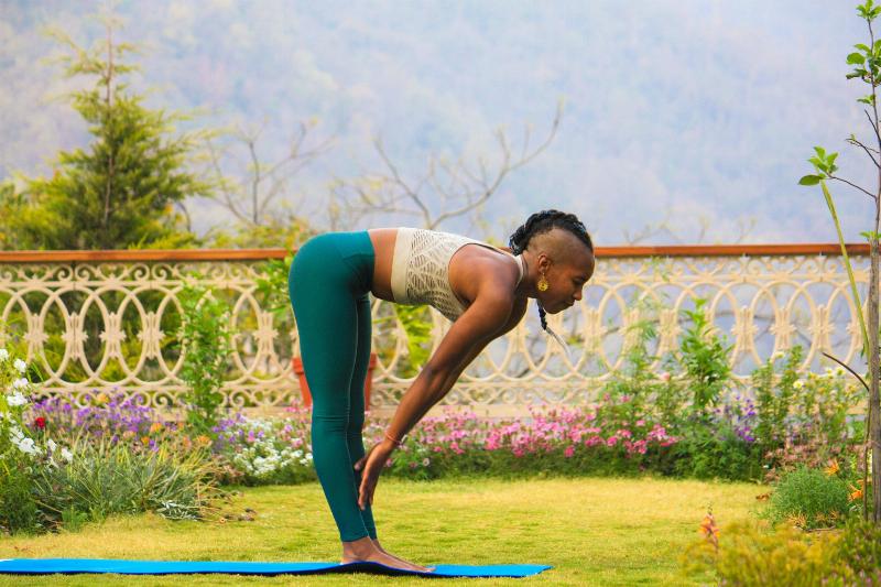 woman practicing yoga in a garden