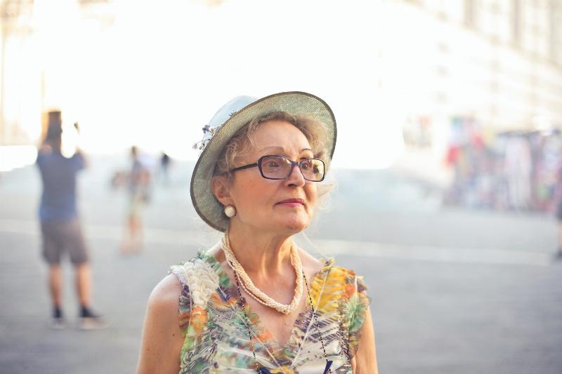 older woman looking off to the side in fedora hat