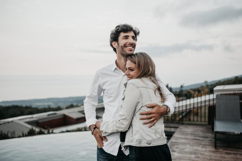 man and woman hug on a roof