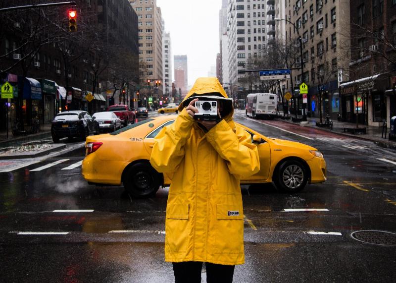 man taking a picture in a yellow coat