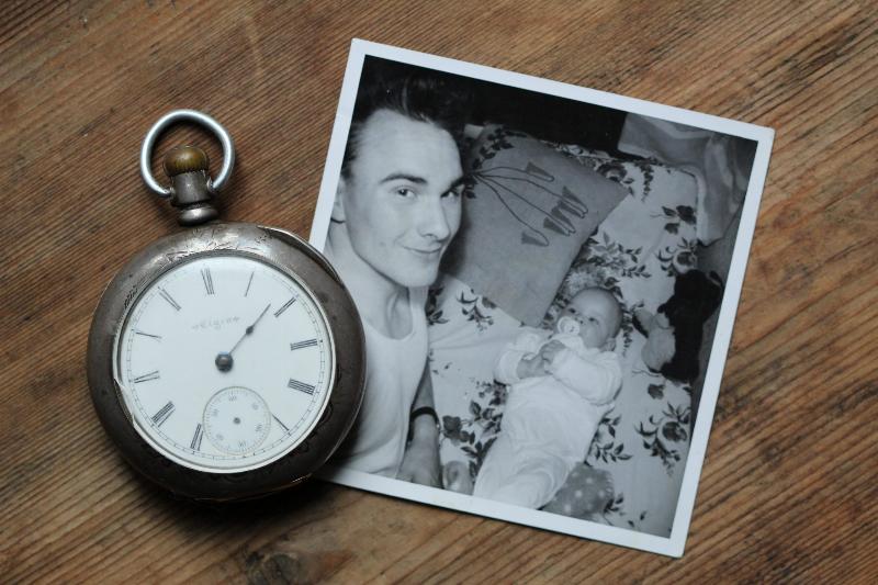 clock beside black and white photo of grandpa and baby