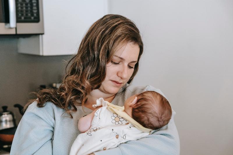woman holding baby up to her chest