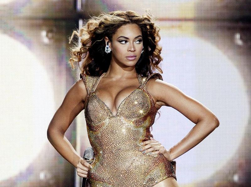 Beyonce performing on stage and posing with her hand on her hip