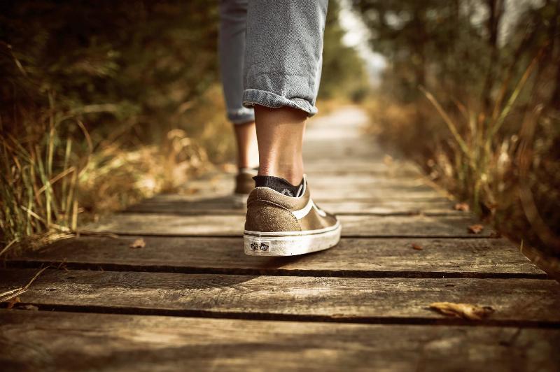 feet walking down wooden path