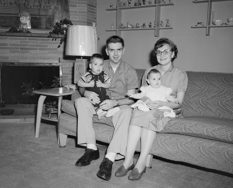 black and white old photo of couple with two babies sitting on couch