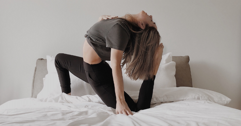 woman doing yoga pose on bed