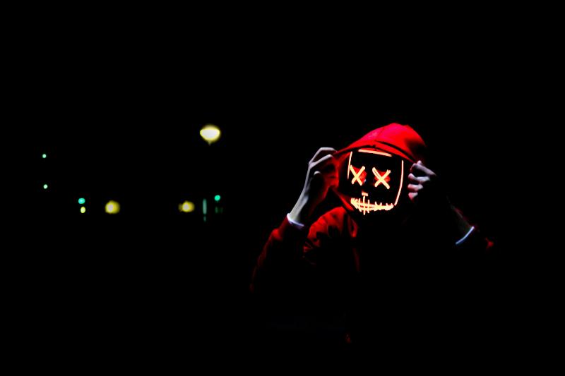 man wearing red hoodie and lit mask
