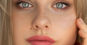 woman looks into the camera holding her face