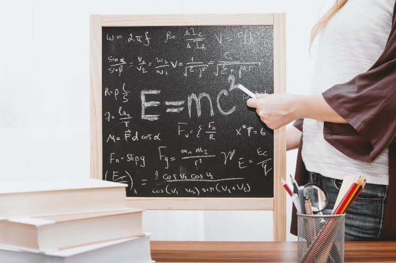 cut off woman writing math on blackboard