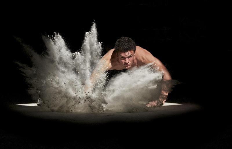 man splashes down a pile of white powder