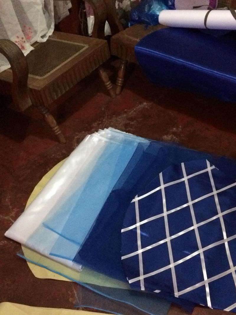 blue material folded and layed out on wooden floor