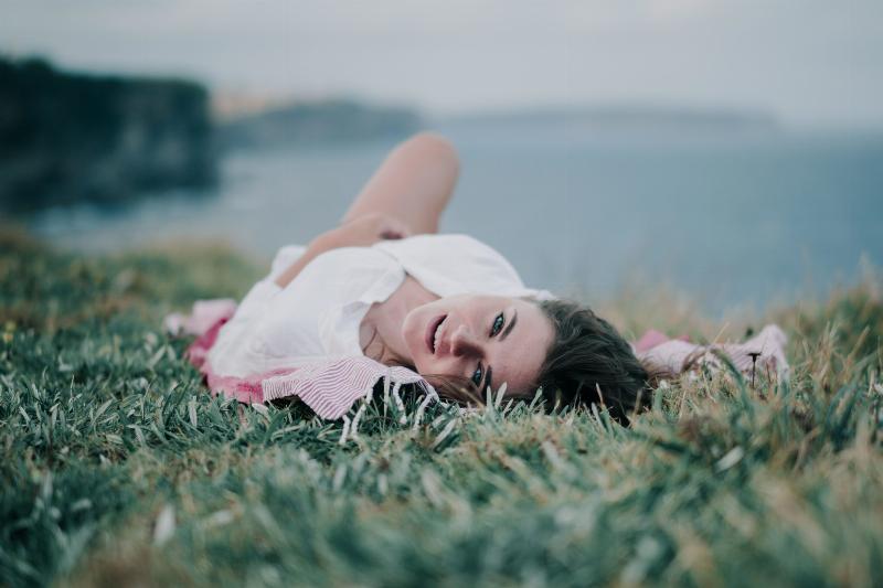 woman laying in the grass looking back