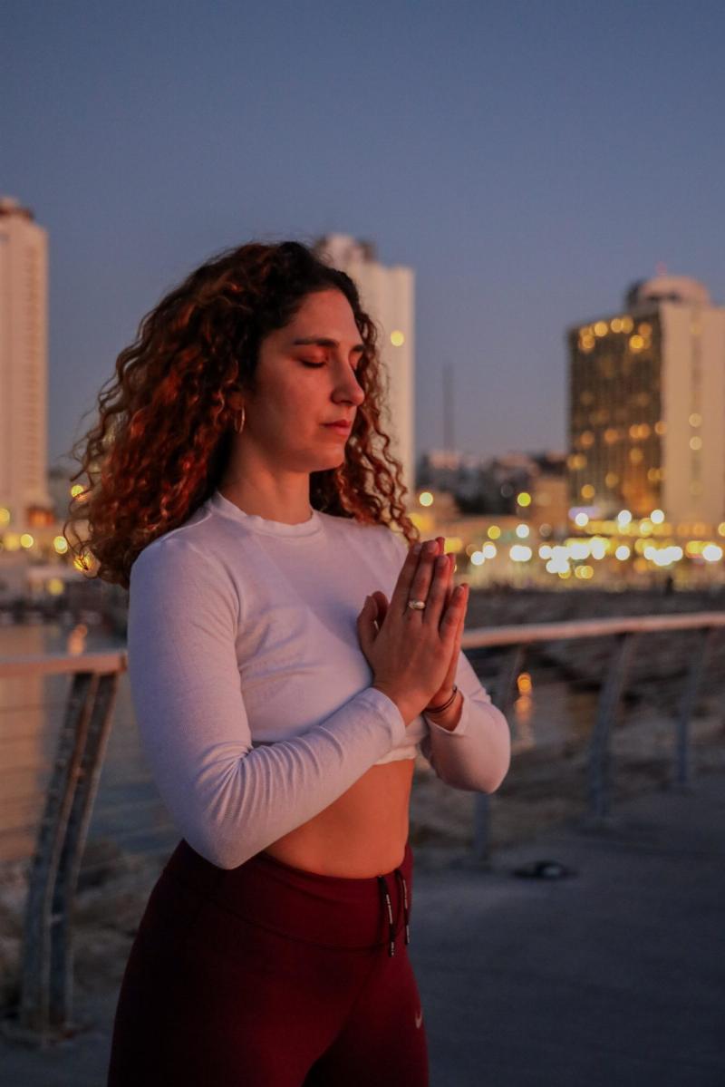 woman meditating in city lights