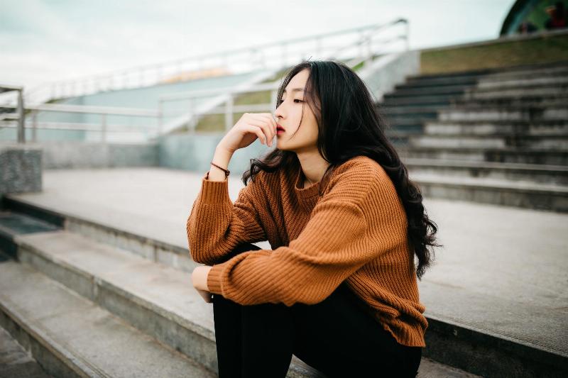 woman sits on bleachers deep in thought