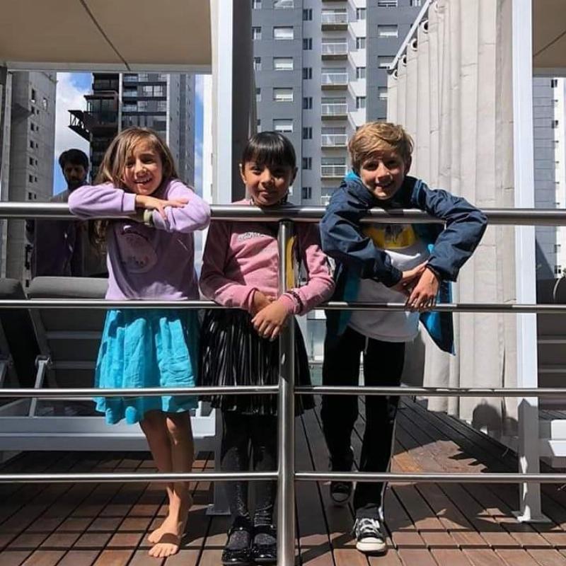Ahara posing with two other kids in front of railing