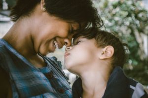 mom and child smile forehead to forehead