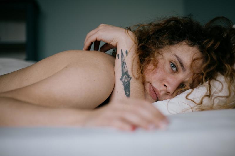 woman laying in bed and looking at camera
