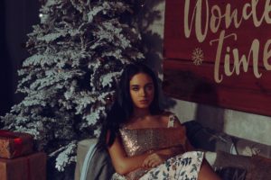 woman hugging pillow by Christmas tree