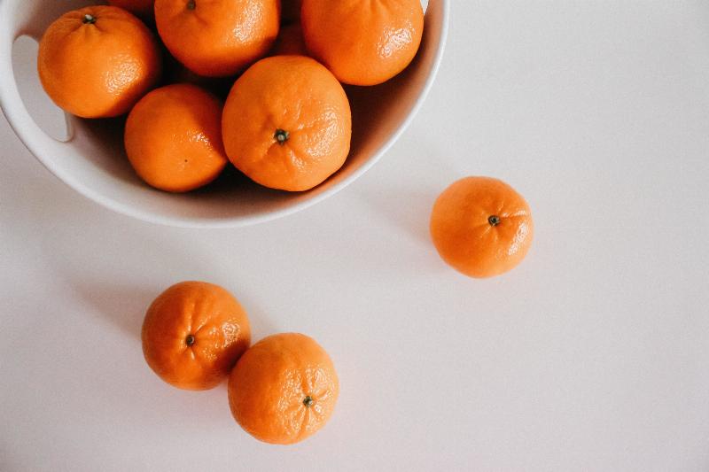 bowl of orange with some orange around it on white counter