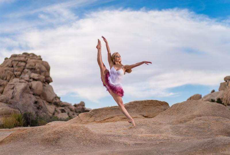 dancer does split jump in desert environment