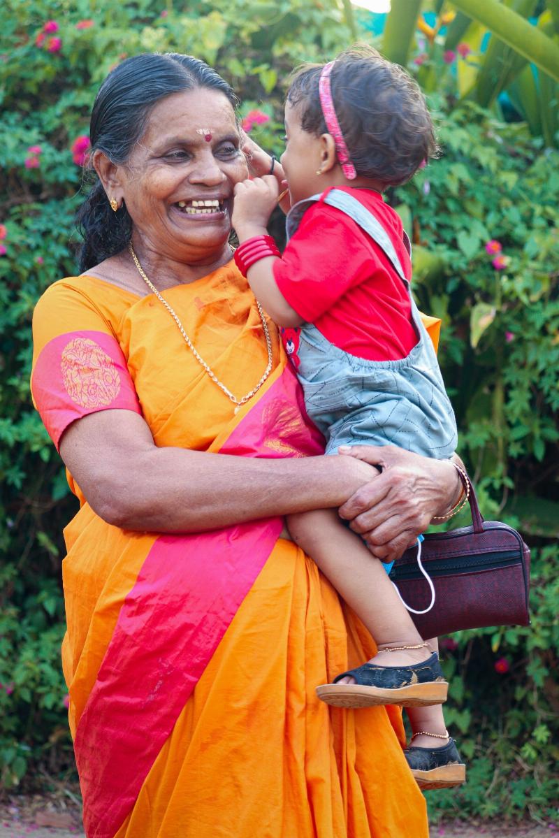 grandma in traditional hindu clothings holding grandaughter