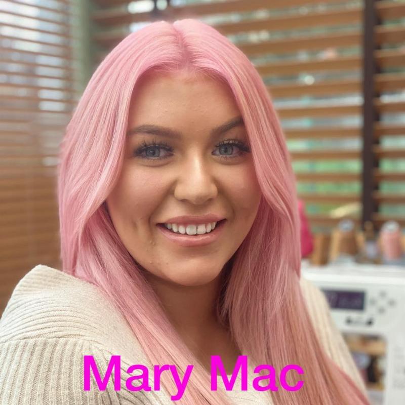 Mary with pink hair, smiles at the camera
