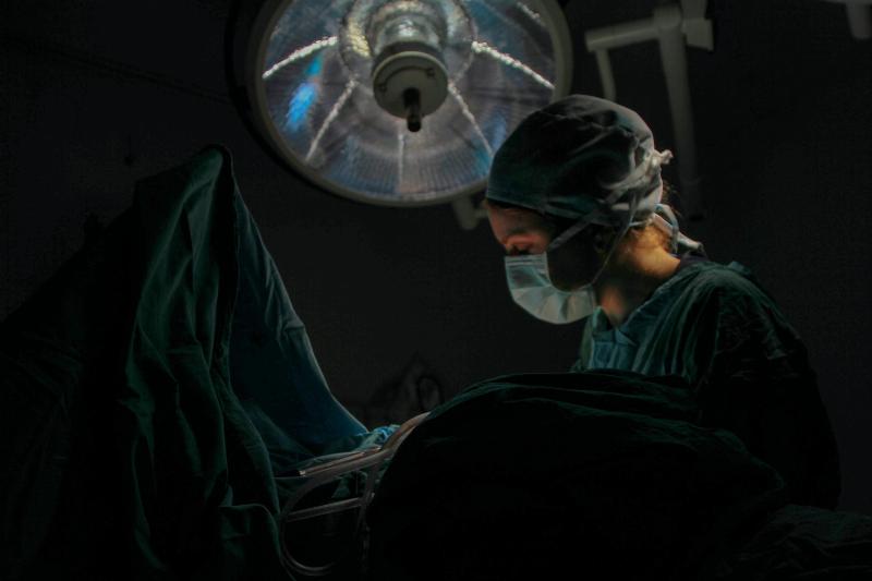 surgeon looking over patient bed