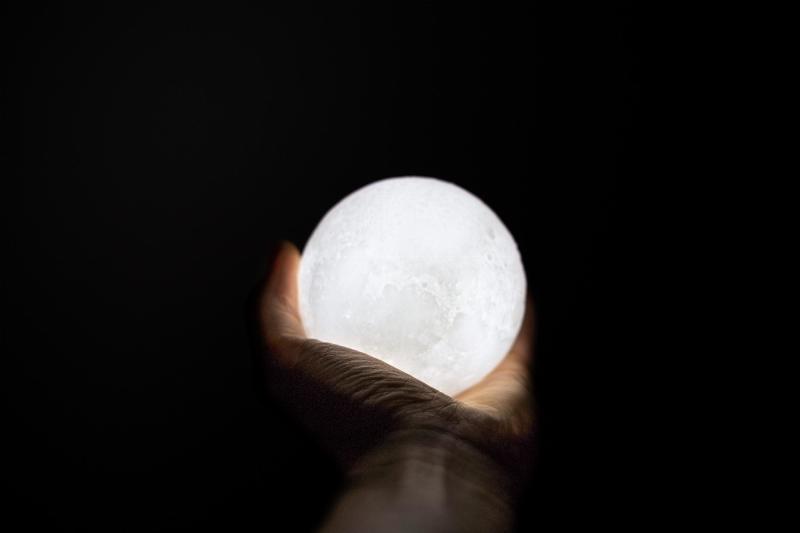 hand in dark background, holding white bubble
