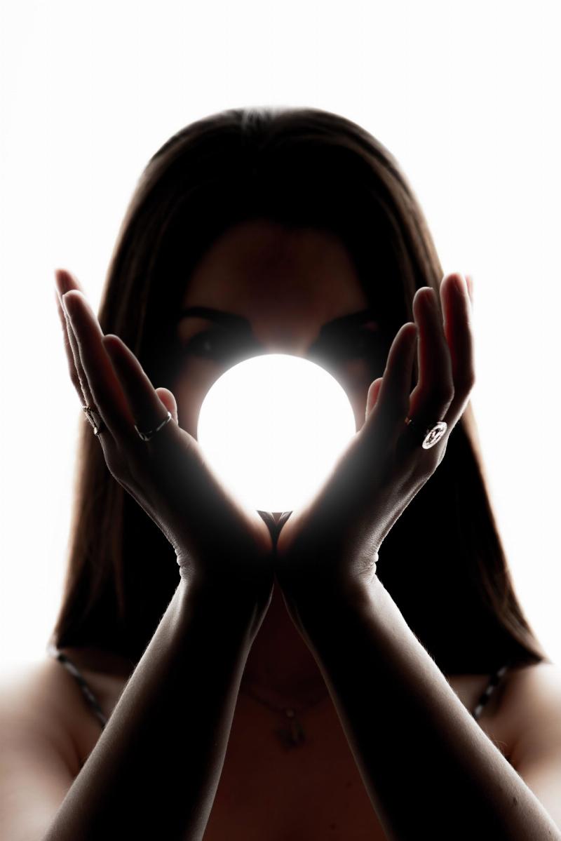 woman holds white light bubble between her hands