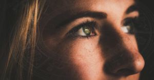 woman looking up with astrology signs faded in background