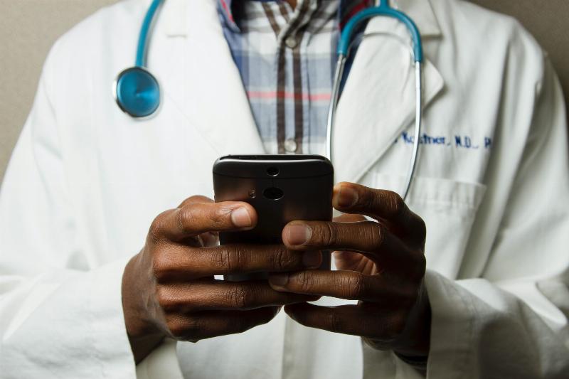 close up on doctor's hands texting