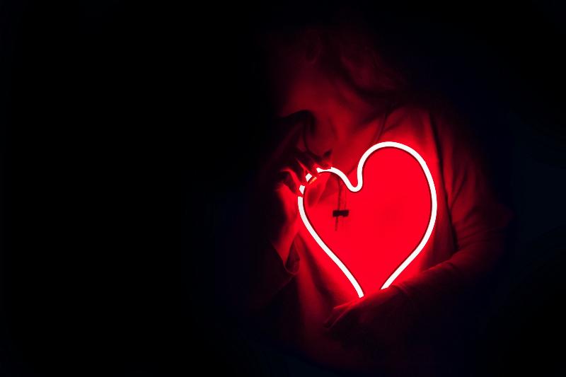 woman holds red LED heart