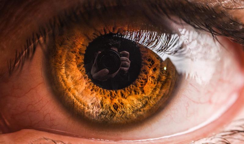 reflection of person taking photo in eye pupil