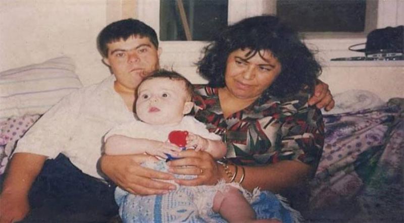 Sader with his parents as a baby looking away