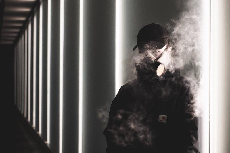 man wearing with mask with smoke around him