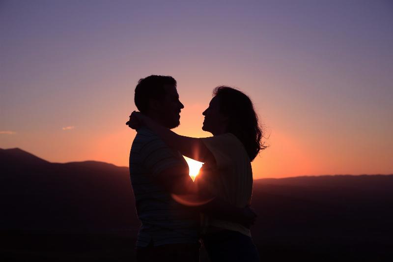 couple stand infront of sunset