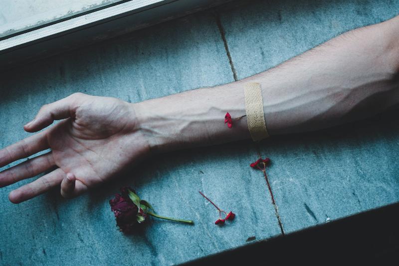 arm laid with flowers and a bandaid over veins