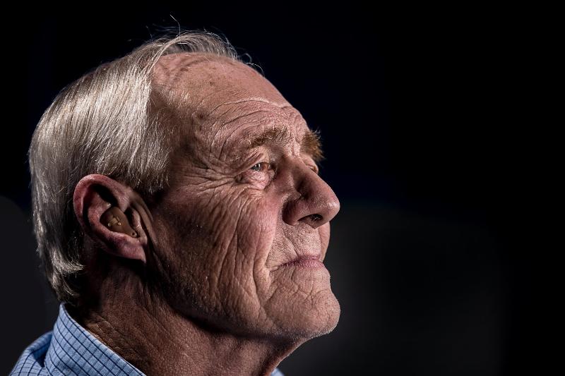 profile of old man smiling with black background