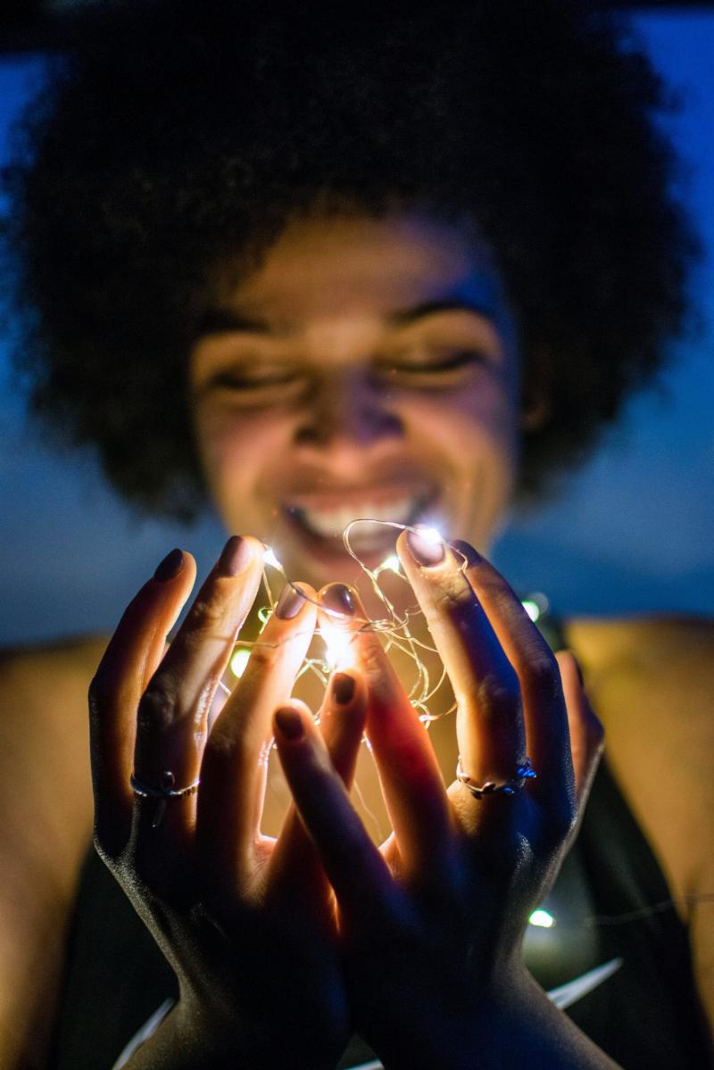 woman holding string lights in her hands
