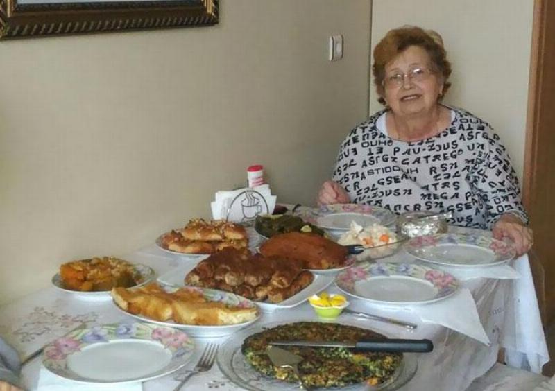 woman sits at table behind her homemade food