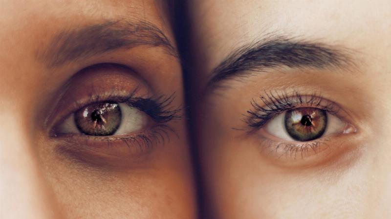 two women touch faces with their eyes beside each other
