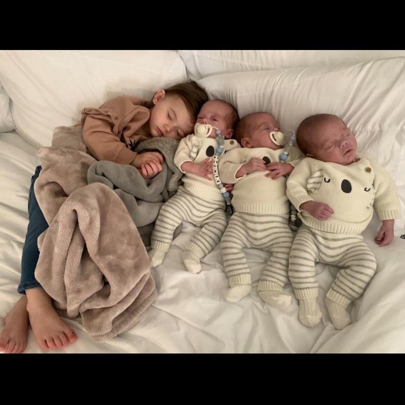 older sister napping with her triplet siblings