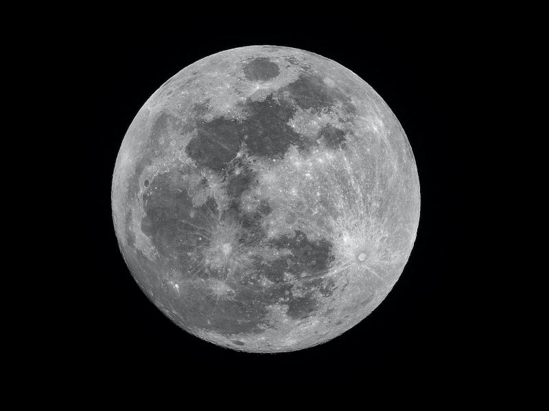 close up of the full moon on black background