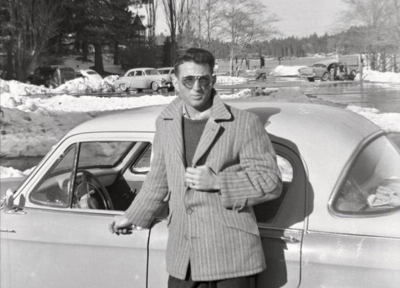 man posing in front of car