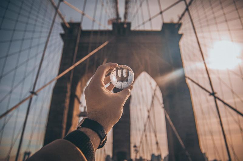 hand holding up ball reflecting the bridge